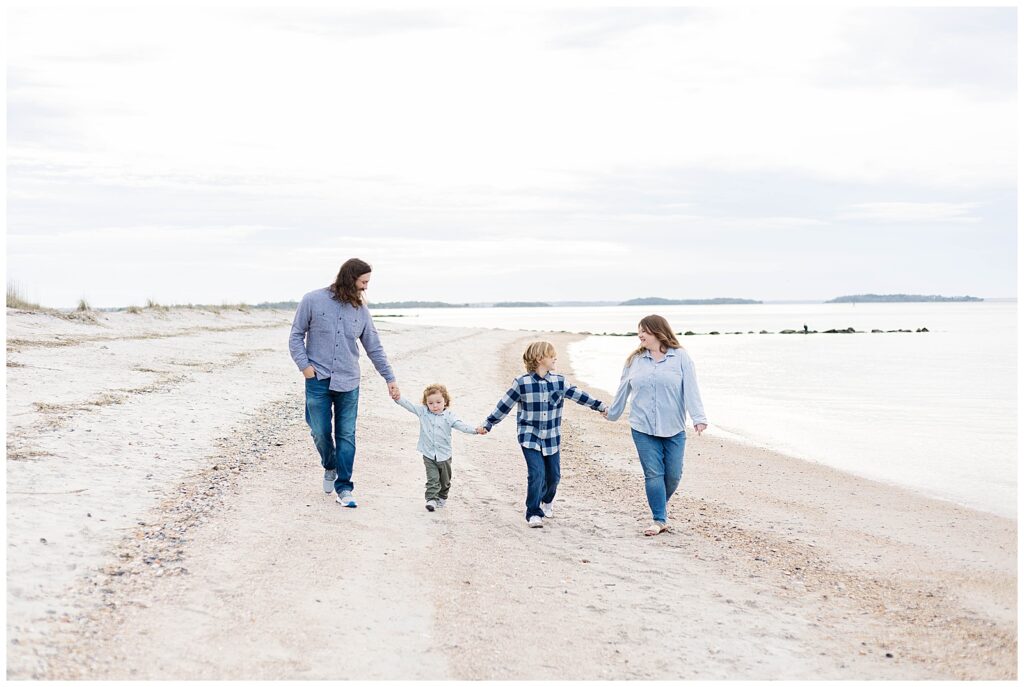 Family walking together along a sandy shoreline