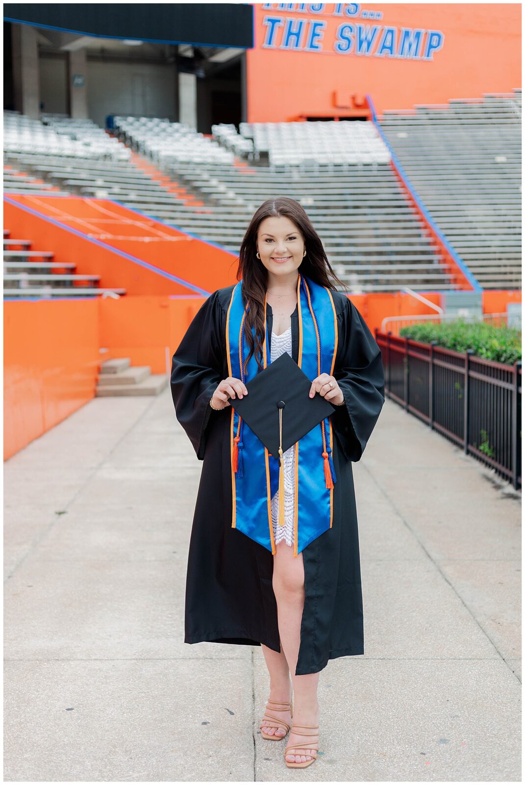 UF grad session portrait of a University of Florida graduate wearing cap, gown, and blue stole