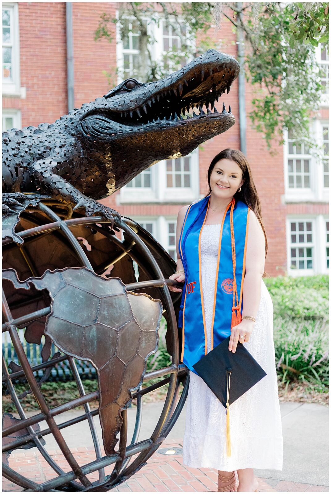 UF grad session photo of a University of Florida senior posing beside the iconic gator globe statue