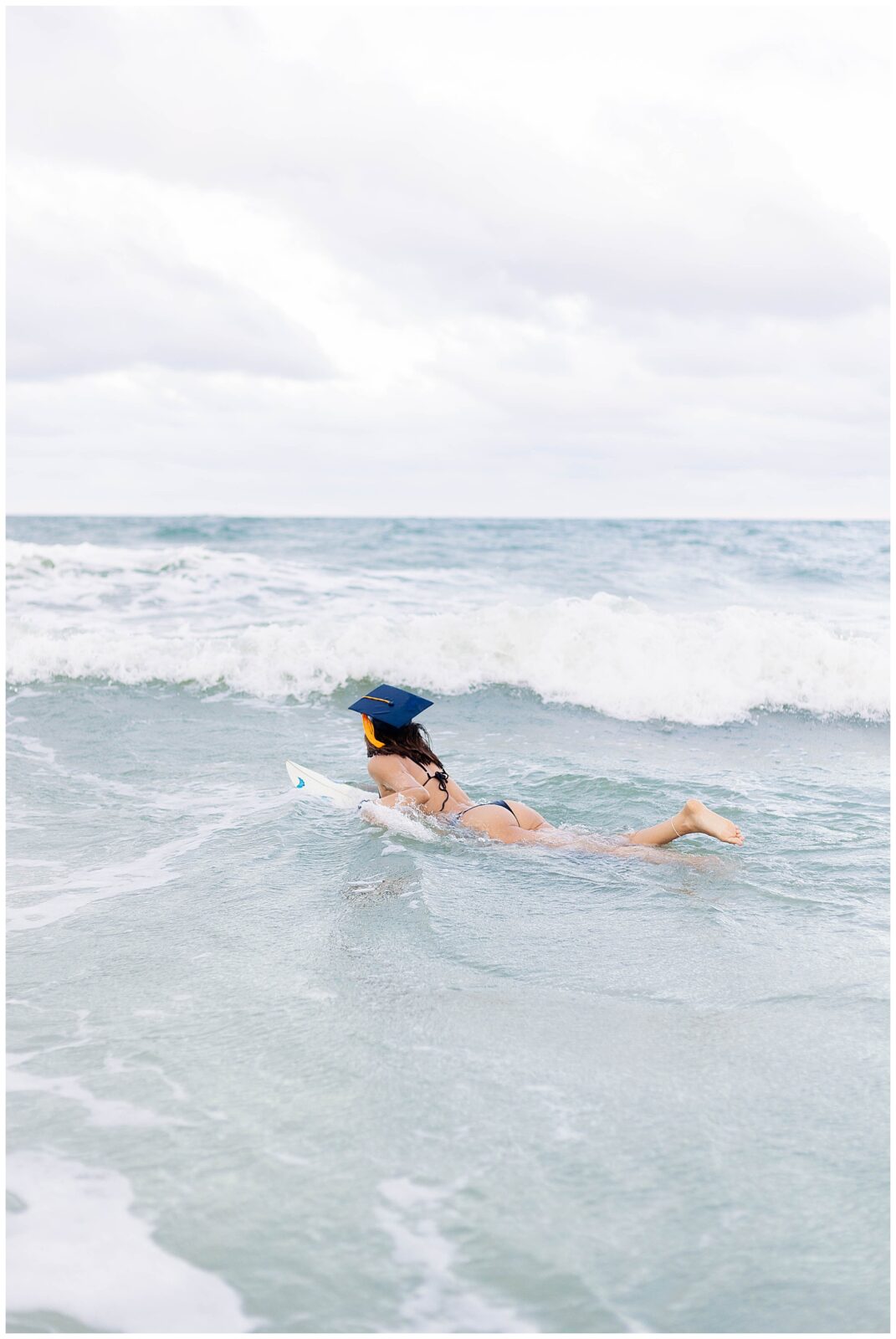 Graduation photo of a UNF graduate enjoying the ocean during a surf-inspired session