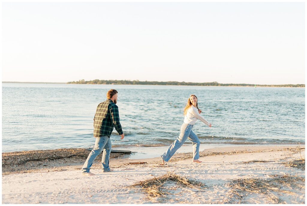 Couple running barefoot near the water at Fort Clinch State Park during a playful beach engagement session